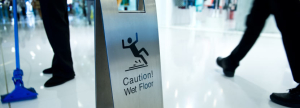 Wet-floor-sign-and-person-mopping-floor